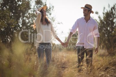 Happy young couple holding hands at farm