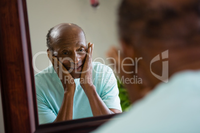 Reflection of concerned senior man on mirror