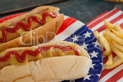 Hot dog served on plate with french fries