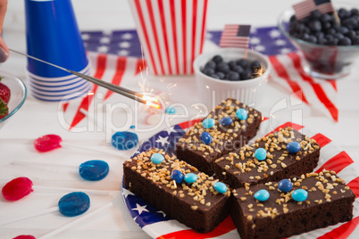 Close-up of sweet food and burning crackers decorated with 4th july theme