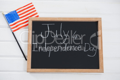 Slate with text and an American flag on wooden table