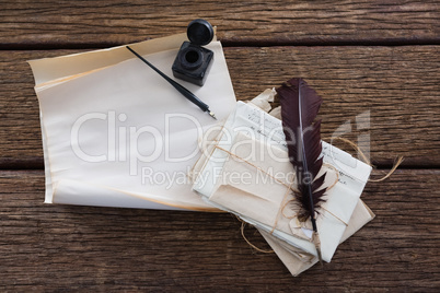 Quill feather, ink bottle, ink pen and legal documents on table