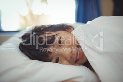 Smiling girl lying on the bed in bed room