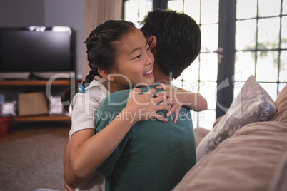 Happy father and daughter hugging each other in living room