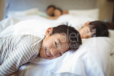 Siblings sleeping on bed in bedroom