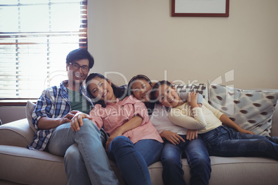 Smiling family relaxing on sofa in living room