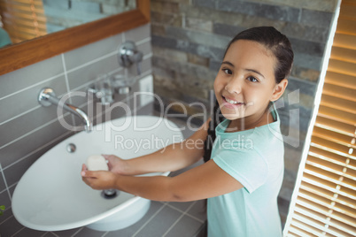 Girl washing hands in bathroom sink