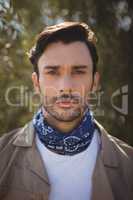 Portrait of young man standing at olive farm on sunny day