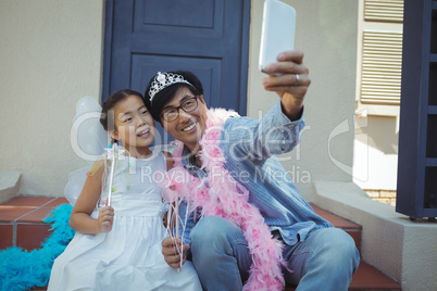 Father and daughter in fairy costume taking a selfie