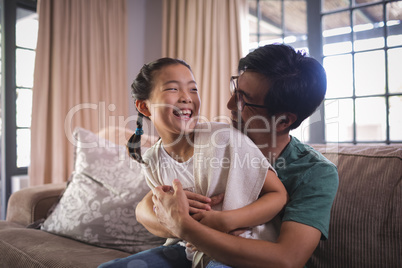 Happy father and daughter having fun in living room