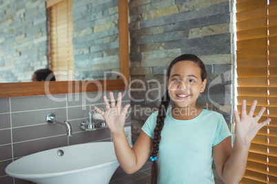 Girl washing hands in bathroom sink