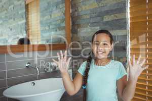 Girl washing hands in bathroom sink