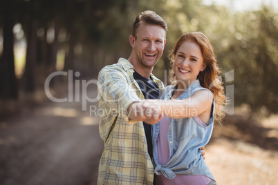 Happy young couple dancing at olive farm during sunny day