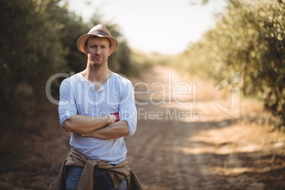 Confident young man standing on dirt road at farm