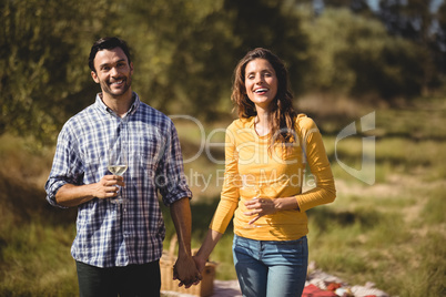 Happy young couple holding wineglasses at farm