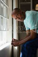 Portrait of serious senior man sitting by window