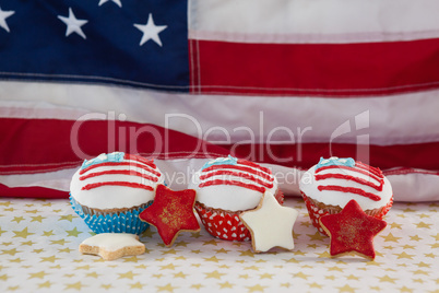 Close-up of decorated cupcakes and cookies arranged on table