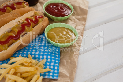 Hot dog, french fries and sauces on brown paper