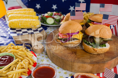 Burgers and corn cob on wooden table with 4th july theme