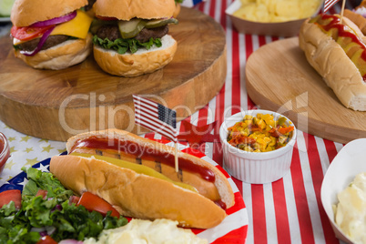 Burgers and hot dogs on wooden table with 4th july theme