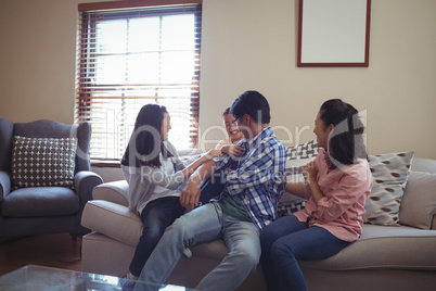 Family having fun together on sofa in living room