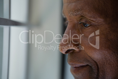 Close up of thoughtful senior man looking out through window