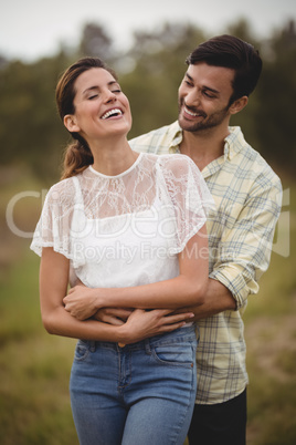 Happy young couple embracing at farm