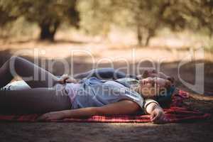 Young couple napping on mat at olive farm