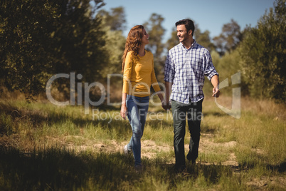Happy young couple holding hands at olive farm