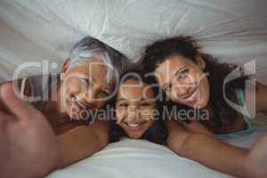 Happy family lying on bed in bed room