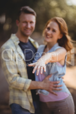 Smiling woman showing ring with man at olive farm
