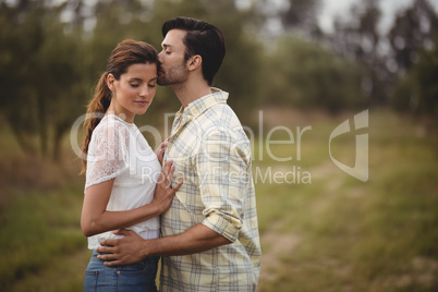 Young couple romancing on field at farm