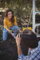 Boyfriend photographing smiling girlfriend at olive farm