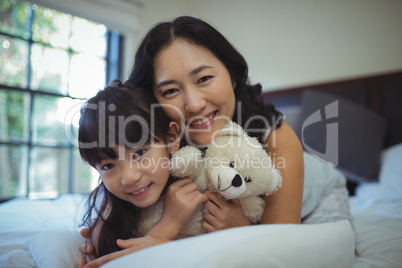 Mother and daughter relaxing on bed in bed room