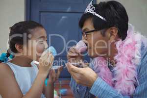 Father and daughter in fairy costume having a tea party
