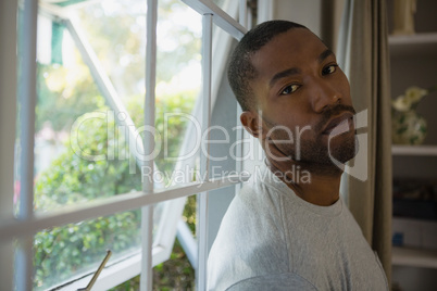 Portrait of man leaning on window