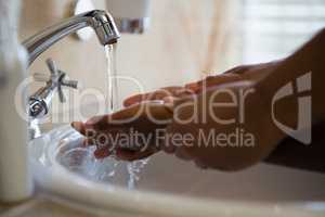 Cropped image of people washing hands in bathroom sink