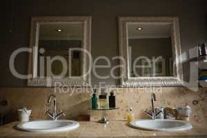 Mirrors hanging on wall by sink in bathroom