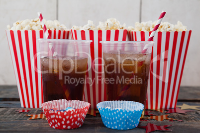 Popcorn, confectionery and drink on wooden table