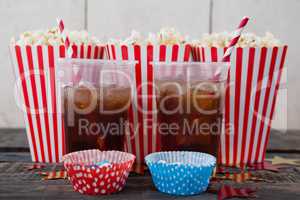Popcorn, confectionery and drink on wooden table