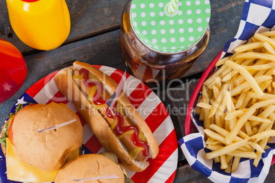 Close-up of snacks and cold drink on wooden table