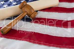 Gavel and rolled-up document arranged on American flag