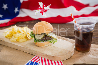 Burger and cold drink on wooden board