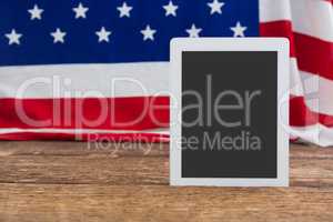American flag and digital tablet arranged on wooden table