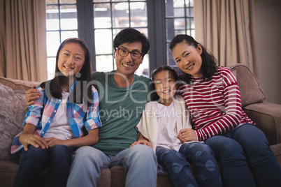 Smiling family relaxing on sofa in living room