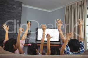 Family watching television together in living room