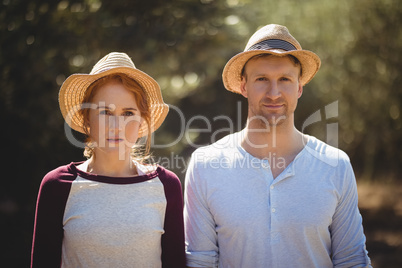 Young couple wearing hat on sunny day at farm