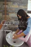 Mother and daughter washing hands in bathroom sink