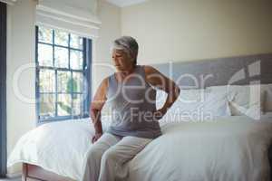 Senior woman suffering from back pain at home