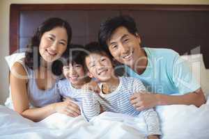 Family sitting together in bedroom
